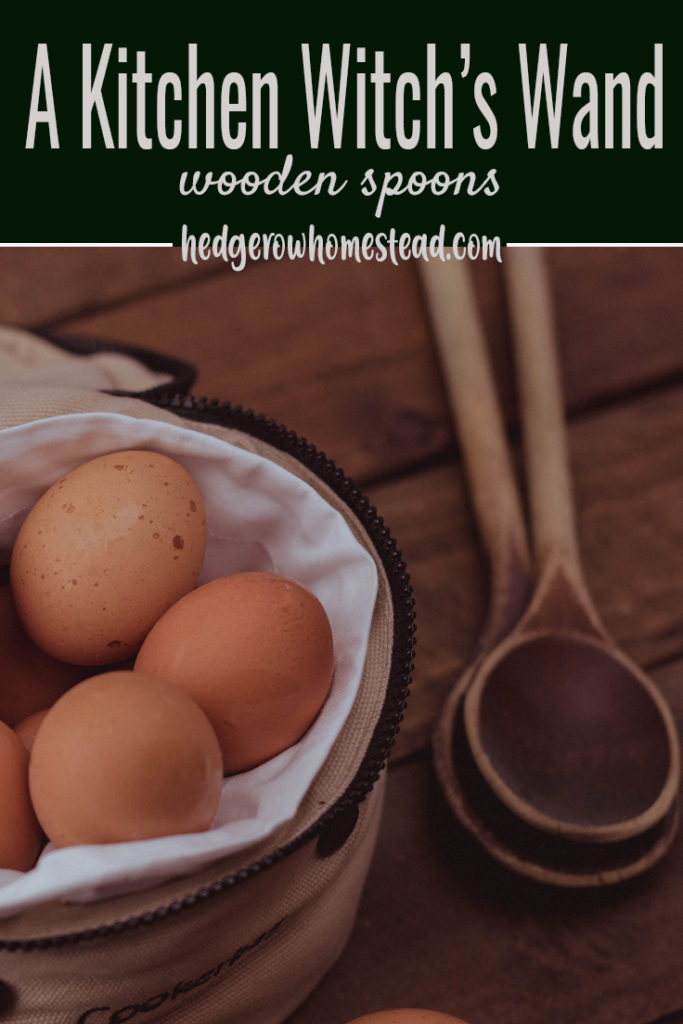 wooden spoons on a wooden surface next to eggs in a basket lined with white cloth