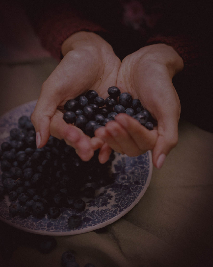 woman holding a handful of blueberries
